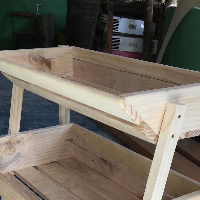 Mesa sensorial em madeira com dois compartimentos abertos, para areia e água.